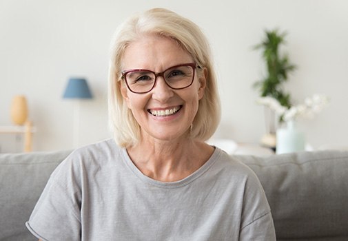 Woman smiling while sitting on couch at home