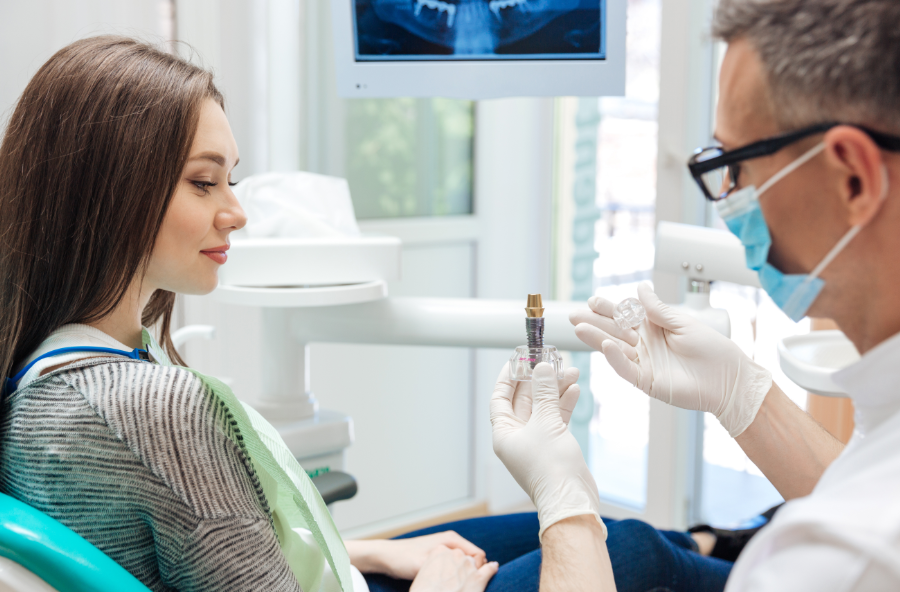 Dentist showing patient dental implant