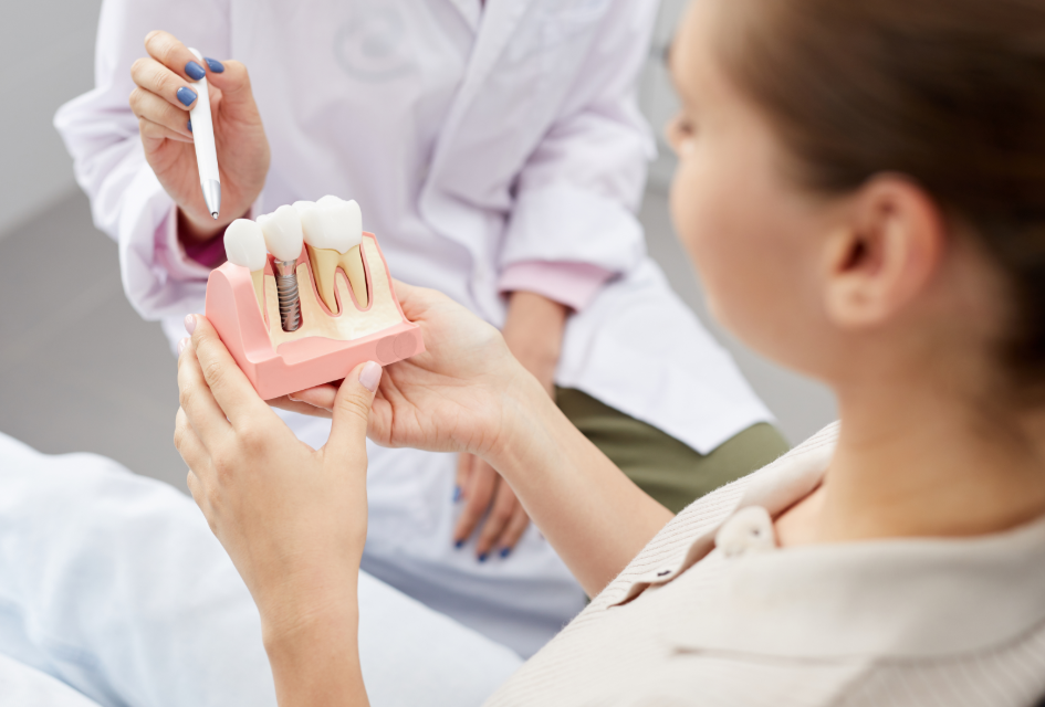 Dentist showing patient model of a dental implant